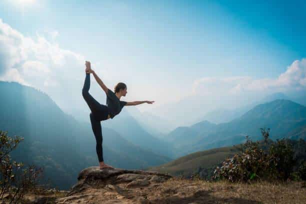 woman seated on paddleboard in yoga pose on a lake near whitefish montana