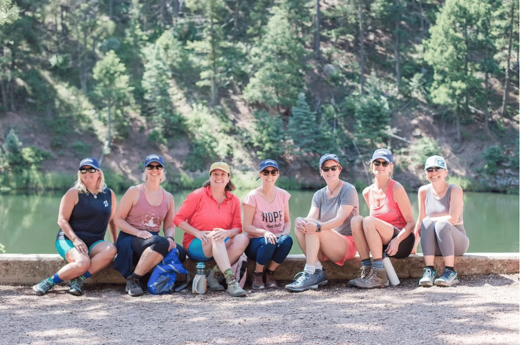woman seated on paddleboard in yoga pose on a lake near whitefish montana
