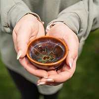 Woman holding pottery bowl symbolizing rest and reset, calm and stillness