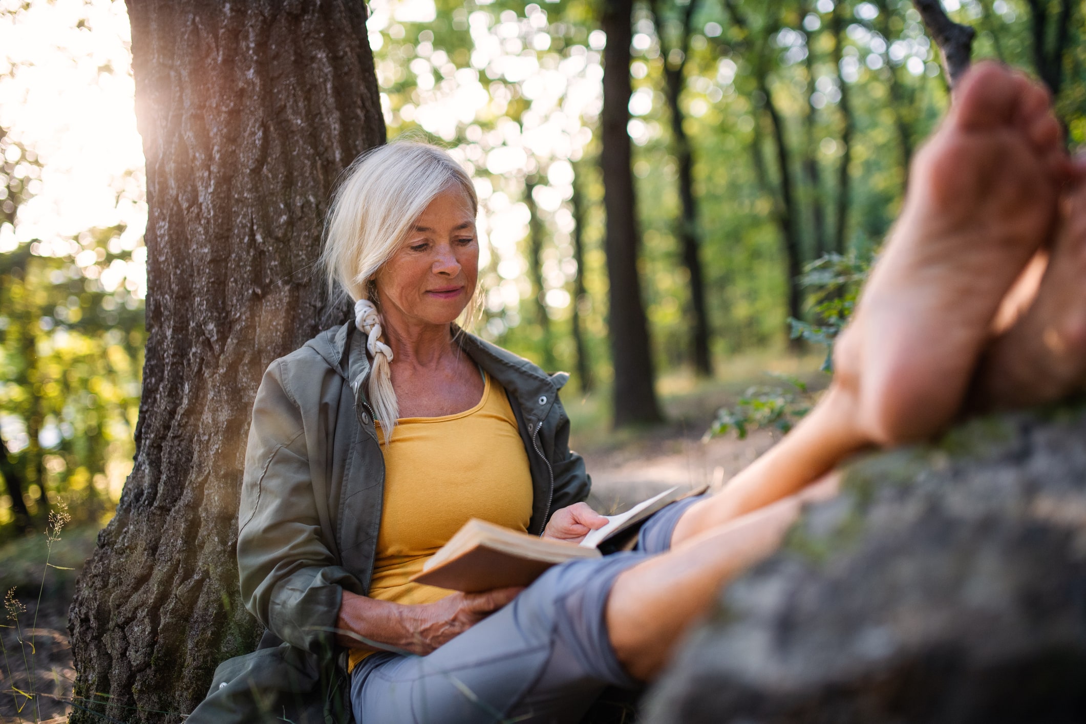 Woman reading in the woods on a relaxing nature immersion retreat in Whitefish Montana